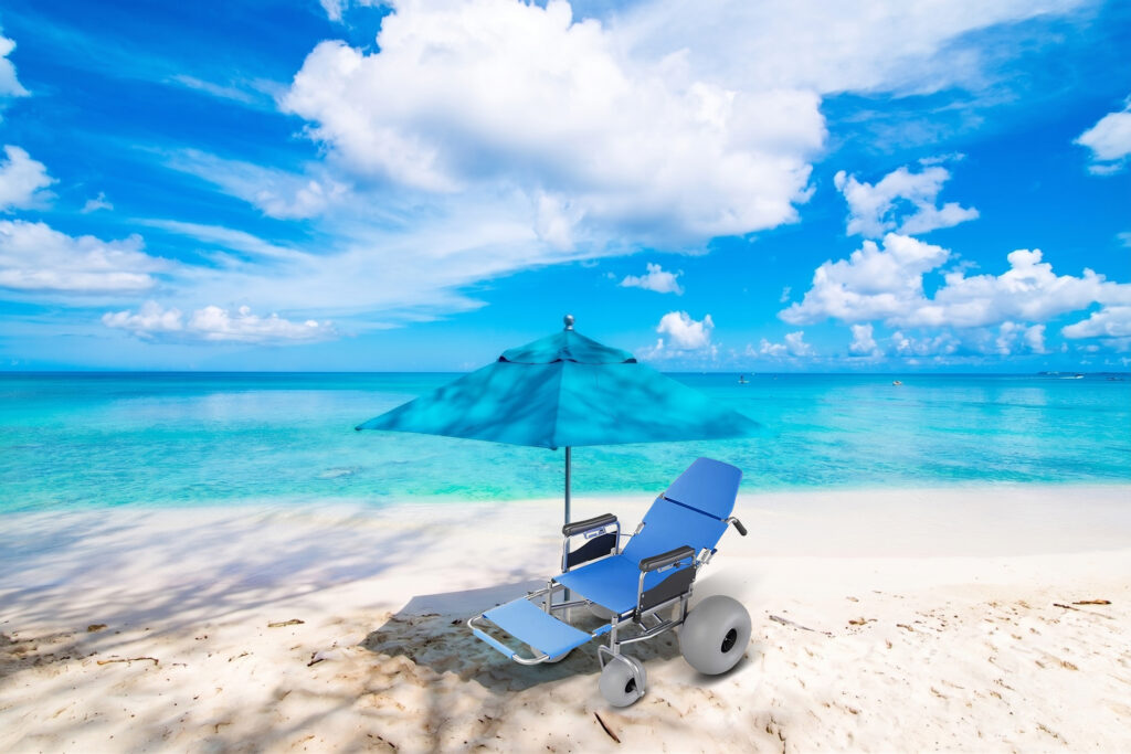 Glide reclining beach wheelchair for hotels on a white sand beach with blue parasol