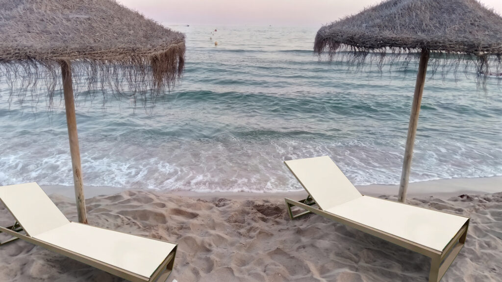 Marbella Classic aluminium sun lounger for hotels on a sandy beach with thatched parasols and sea view
