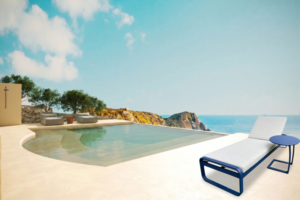 Monaco Elite designer sun lounger with blue frame beside a luxury infinity pool and sea view
