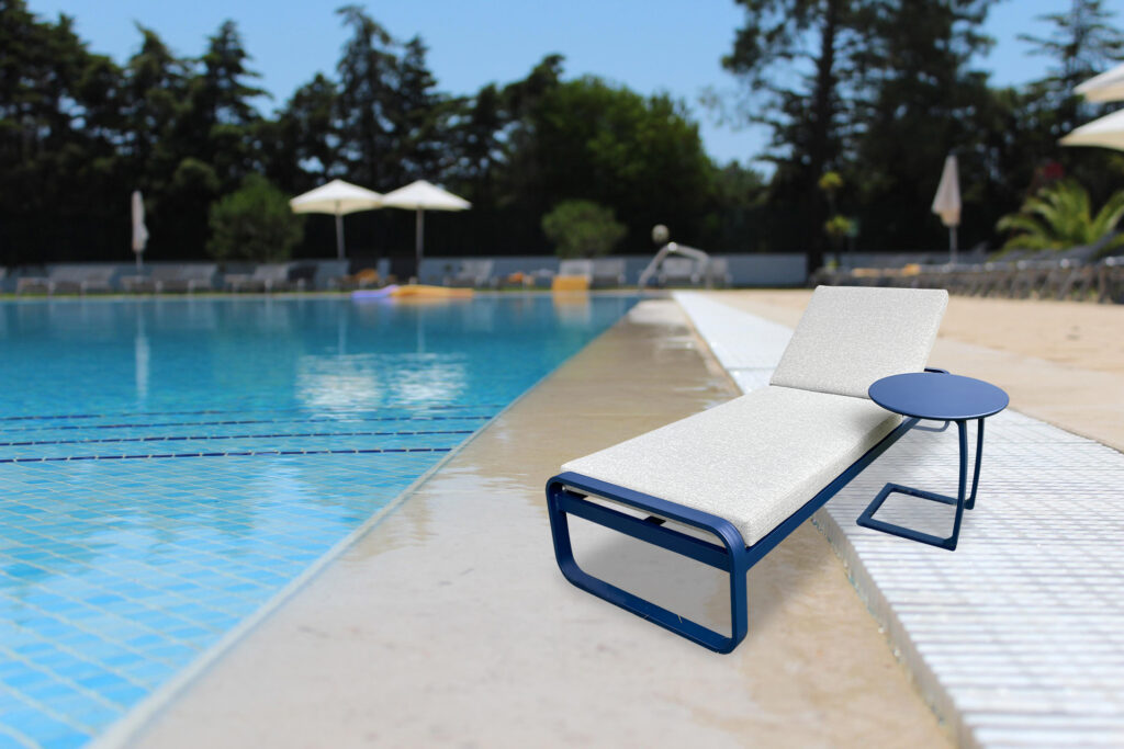 Monaco Elite designer sun lounger for hotels with signature blue frame beside a hotel pool